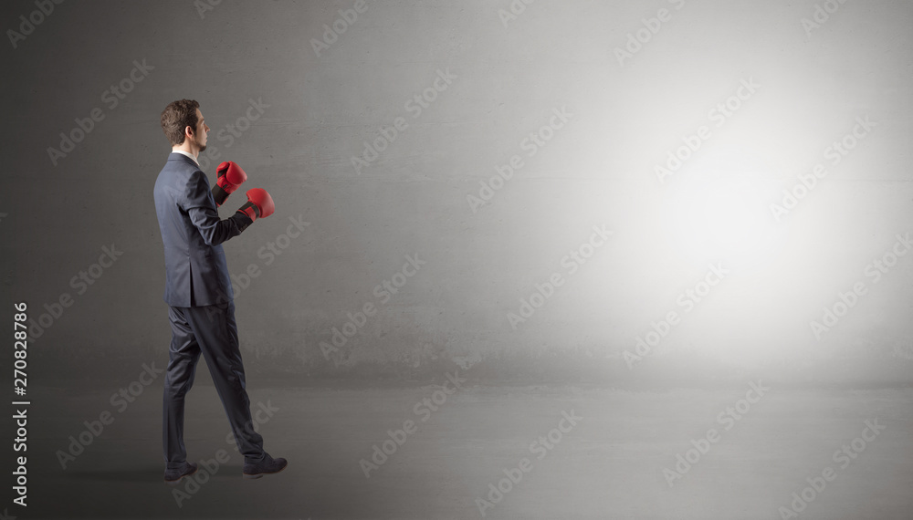 Businessman fighting with boxing gloves in an empty space
Businessman fighting with boxing gloves in an empty space