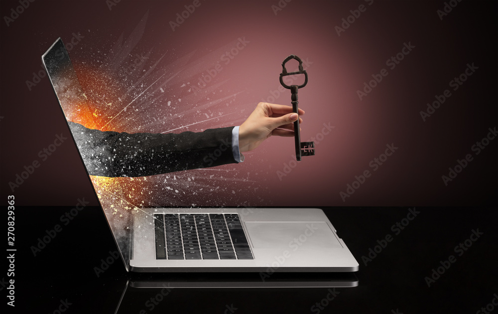 Hand with vintage huge key coming out of a laptop with sparkling