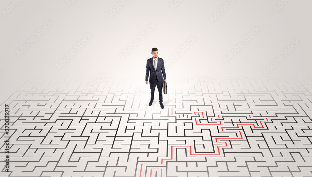 Young entrepreneur standing in a middle of a labyrinth with the solution
Young entrepreneur standing in a middle of a labyrinth with the solution