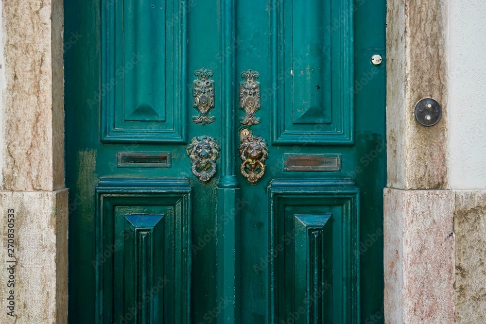 Tür mit Löwenköpfen aus Messing als Türklopfer in Lissabon