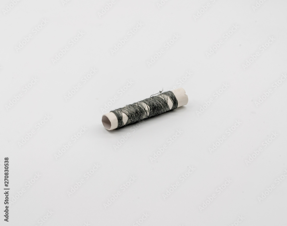 Obraz premium sewing thread of grey color on a white background