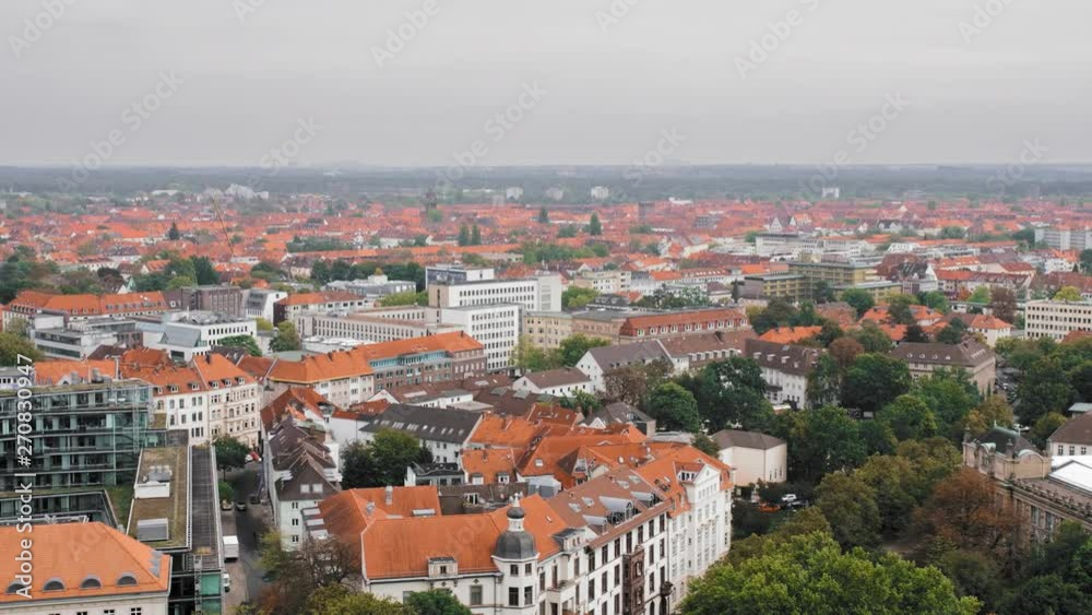 Hannover, Germany a bird's-eye view. Lots of trees and green spaces. City center, Residential buildings and the road. Typical European city with red roofs. Slow Motion. Hannover, Germany a bird's-eye view. Lots of trees and green spaces. City center, Residential buildings and the road. Typical European city with red roofs. Slow Motion.