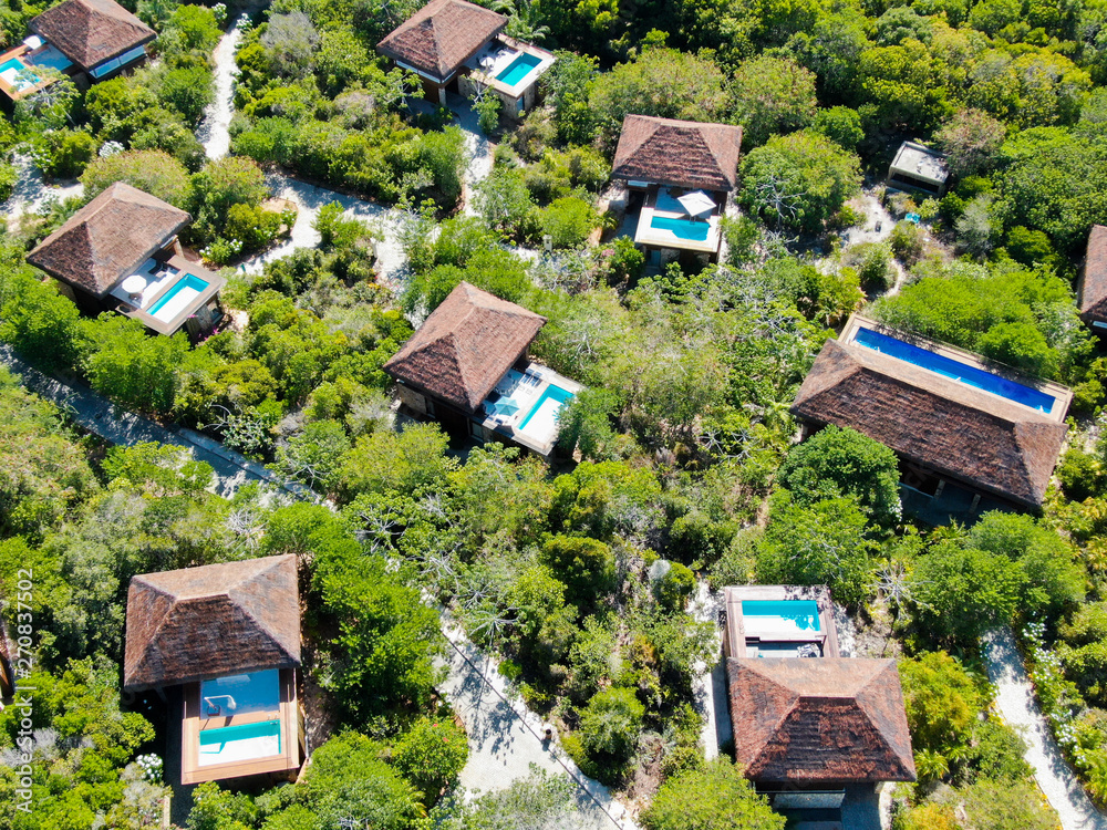 Aerial view of luxury villa with swimming pool in tropical forest. Private tropical villa with swimming pool among tropical garden with palm trees next to the coast. Praia de Forte, Bahia, Brazil Aerial view of luxury villa with swimming pool in tropical forest. Private tropical villa with swimming pool among tropical garden with palm trees next to the coast. Praia de Forte, Bahia, Brazil
