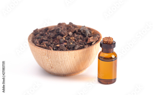 Bowl of Myrrh with a Bottle of Essential Oil on a White Background