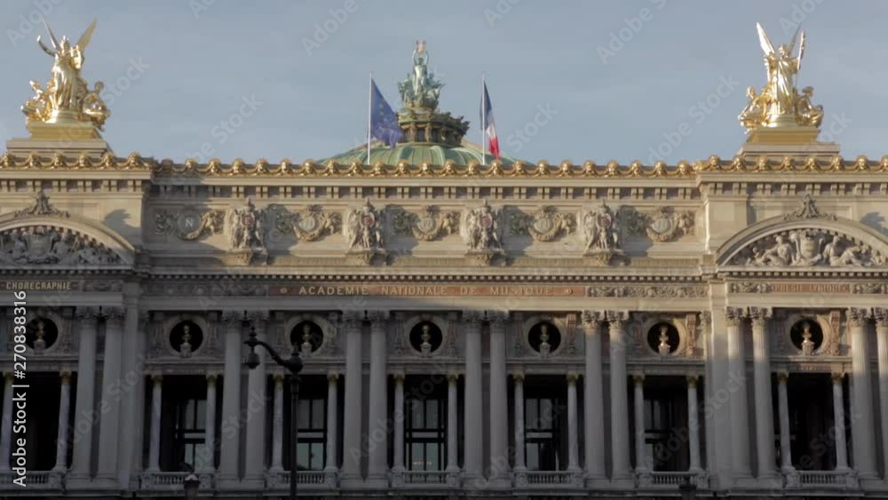 Parisian monument background at Opera place. Gold statue historical sculptures with french flag and european UE flag fluttering in the wind with beautiful blue sky during summer afternoon in Paris. Parisian monument background at Opera place. Gold statue historical sculptures with french flag and european UE flag fluttering in the wind with beautiful blue sky during summer afternoon in Paris.