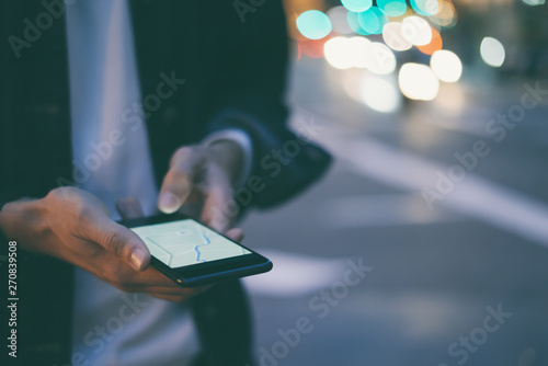 Close up of man's hands with smartphone. Tourist using GPS map navigation on application screen for direction to destination address in the city. Travel and technology concept photo