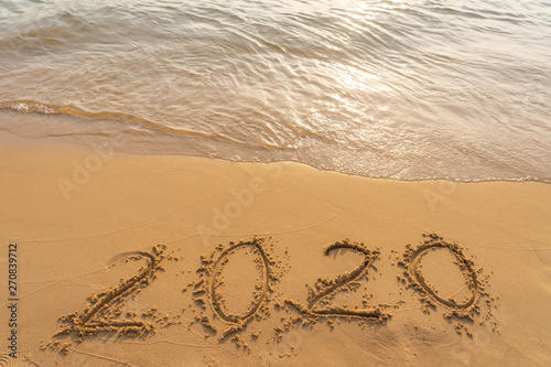New year 2020 on sandy beach with waves