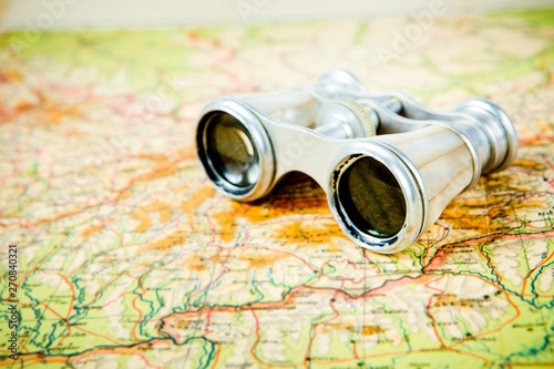 Vintage binoculars with perl grips on old map