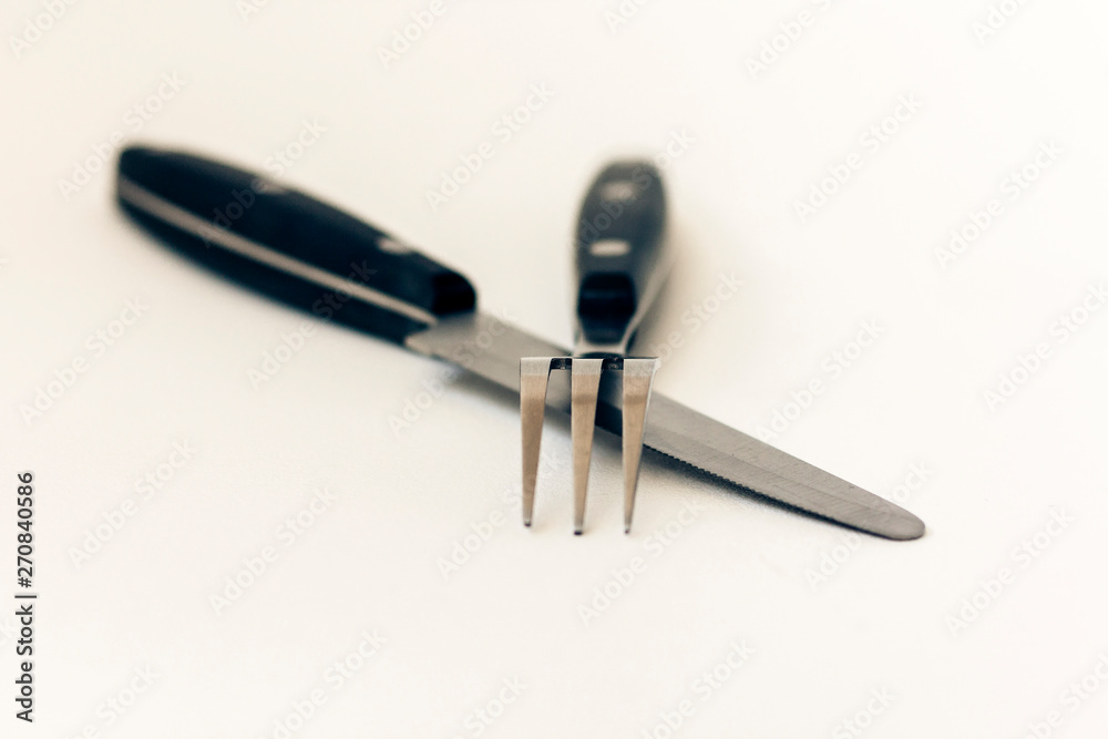 Fototapeta premium Close up knife and fork crossed, isolated on white background.