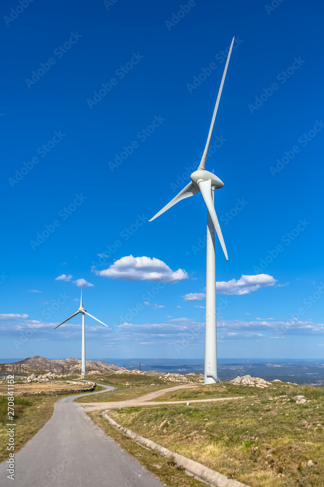 View of a mountains landscape with wind turbines on top View of a mountains landscape with wind turbines on top