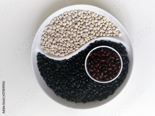 Yin Yang of black white brown beans on a round platter photo