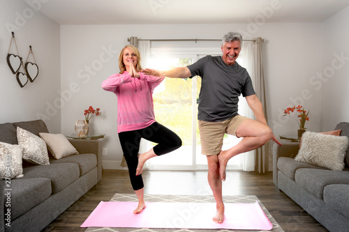 Photography Middle aged retired couple practicing beginner starter yoga pose, fun fitness at