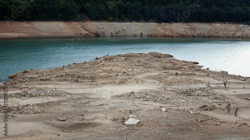 Apocalyptic remains of long time ago flooded village Velika Lukanja showing up during minimum water level of the Zavoj lake photo