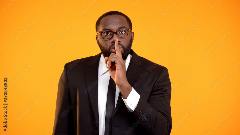 African-american manager showing quiet sign, gossips, personal data disclosure African-american manager showing quiet sign, gossips, personal data disclosure