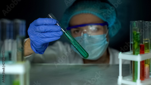 Fototapeta Naklejka Na Ścianę i Meble -  Researcher analyzing blue transparent liquid in tube, laboratory experiment