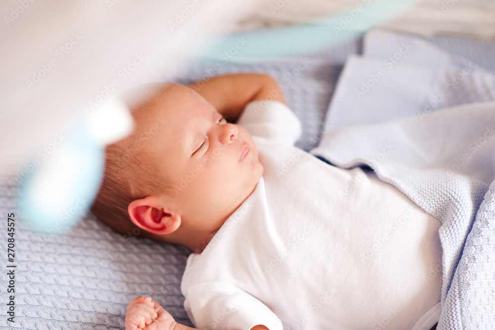 Sleeping baby boy lying in bed closeup. Good morning. Childhood.