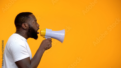 Slika na platnu African-American man using megaphone for protest, calling to action, side view