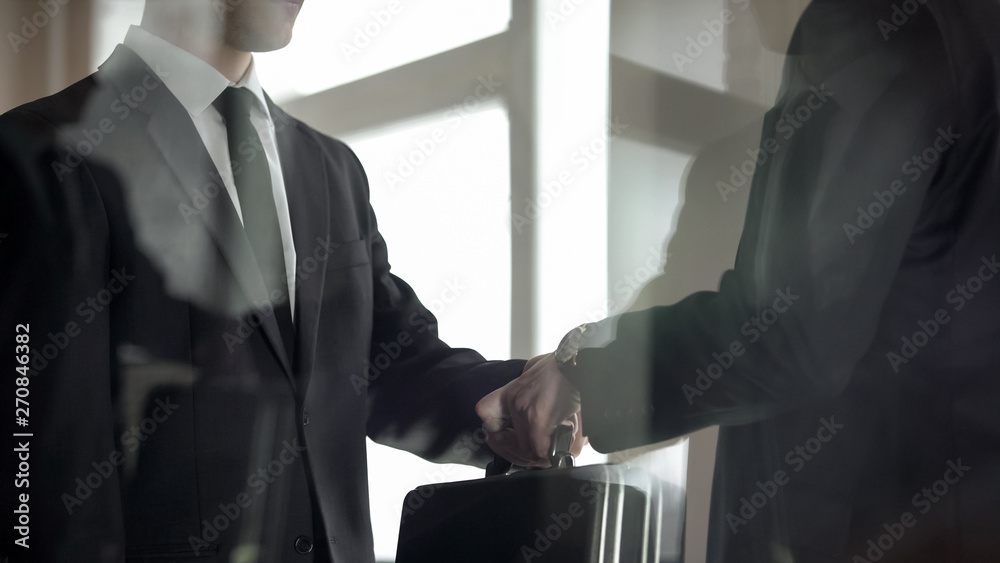 Man handing over briefcase to another man in business suit, secret transfer - obrazy, fototapety, plakaty 