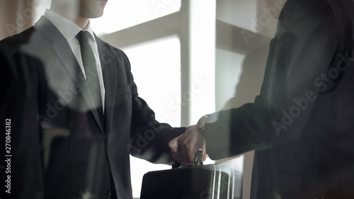 Fotografie Man handing over briefcase to another man in business suit, secret transfer