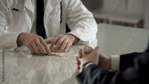 Patient paying dollars cash to doctor for expensive operation  medical reform