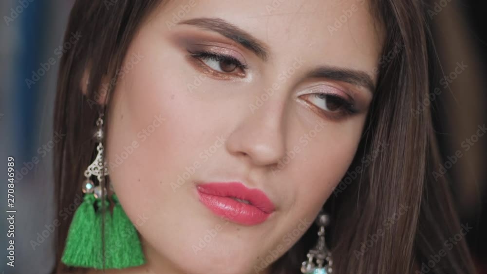 Closeup portrait of young beautiful brunette woman with bare shoulders, gorgeous eyes adorable smile, trendy makeup and brush earrings having fun in her room indoors looking at camera, flirting with Closeup portrait of young beautiful brunette woman with bare shoulders, gorgeous eyes adorable smile, trendy makeup and brush earrings having fun in her room indoors looking at camera, flirting with