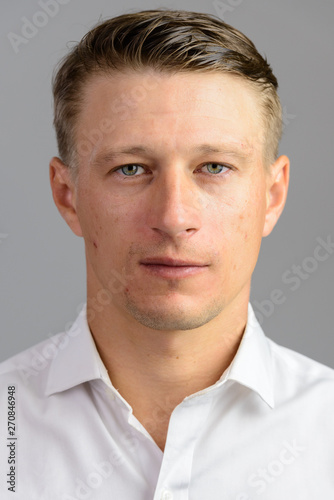 Portrait shot of young handsome Caucasian man isolated against g