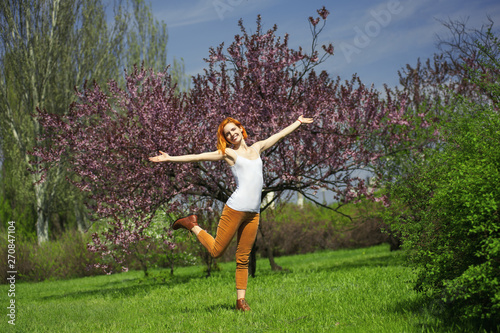 Cheerful girl enjoying nice warm weather in sunny blooming park
