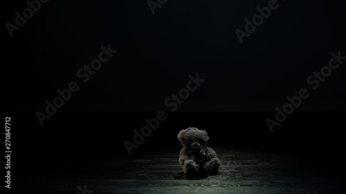 Fotografía Teddy bear toy in dark room, loneliness and lost childhood concept, sadness