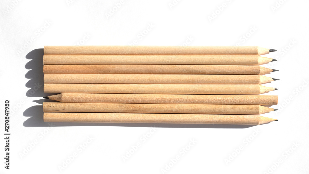 Many pencils are on the table in bright daylight. Natural unpainted wood. Eco-friendly materials. Not like everyone else