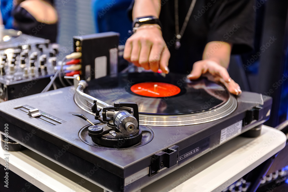 Obraz premium The hands of the DJ spin a record. Close up. Blurred background