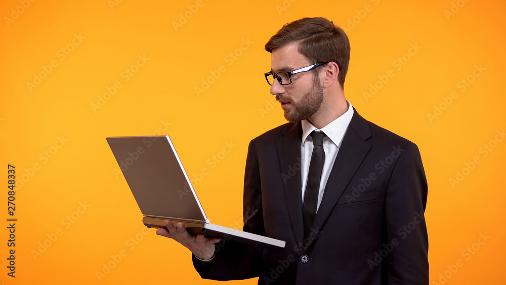 Businessman holding laptop in hand, reading email, checking new software work Businessman holding laptop in hand, reading email, checking new software work