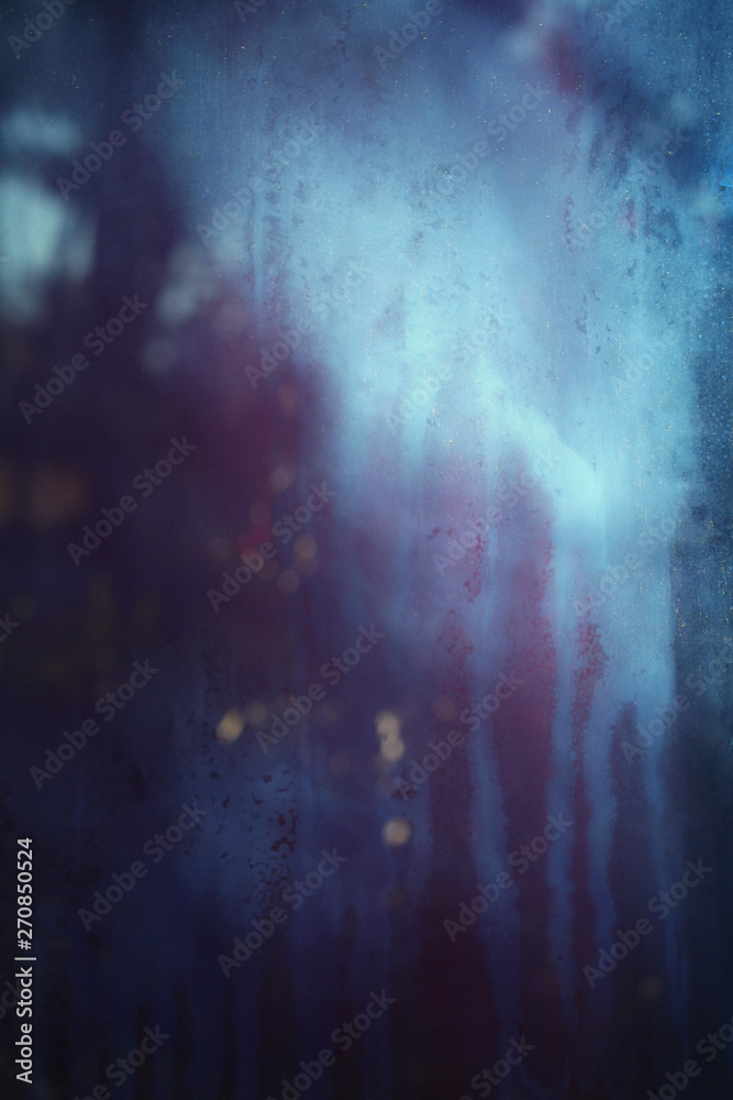 Old dirty dusty window glass with mystical reflection. Soft focus.  Abstract background with scratches. Blue and magenta color.