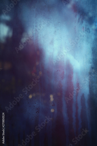 Old dirty dusty window glass with mystical reflection. Soft focus. Abstract background with scratches. Blue and magenta color.