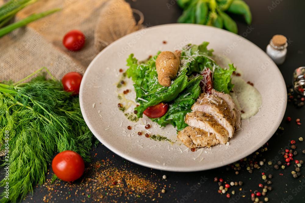 Healthy Grilled Chicken Caesar Salad with Cheese and Croutons. Healthy food, top view. Black background . Slow-mo Healthy Grilled Chicken Caesar Salad with Cheese and Croutons. Healthy food, top view. Black background . Slow-mo