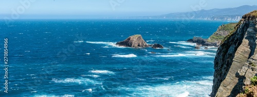 waves running against the cliffs of Cabo Busto on a stormy day at the coast of the Bay of Biscay photo