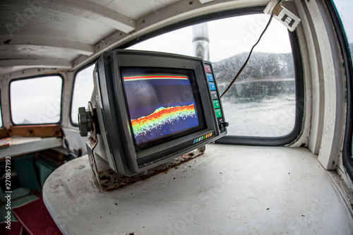 A sonar mounted in a wooden fishing boat, showing the sea bed. photo