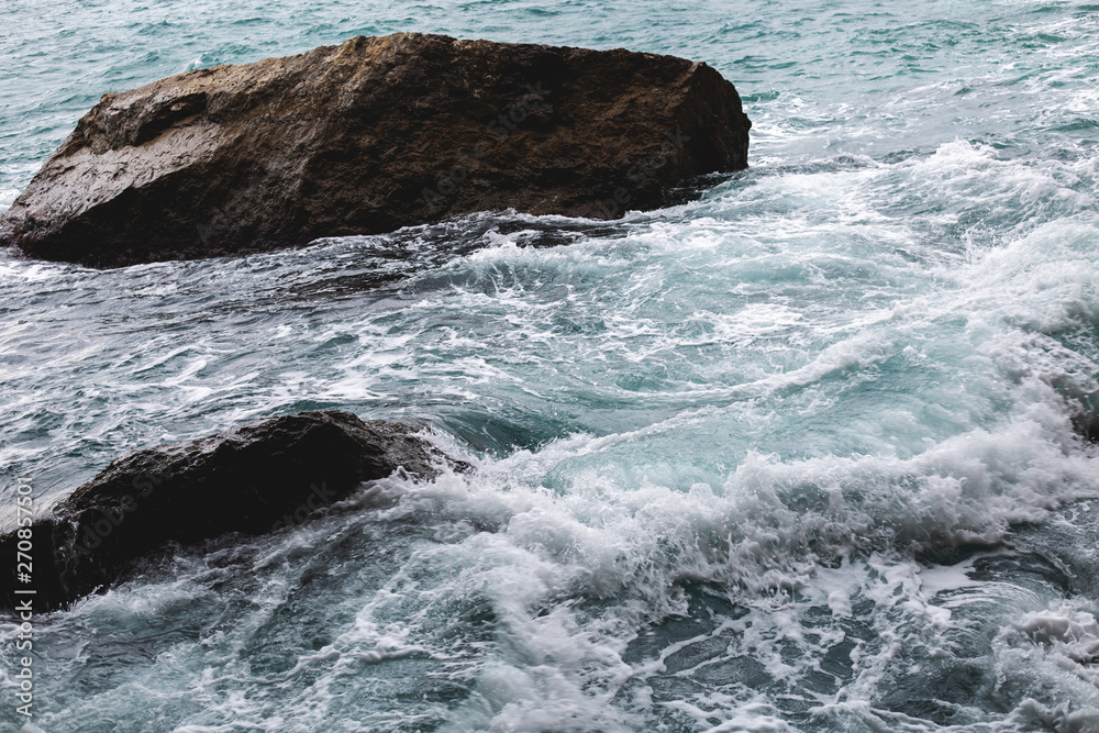Aerial top view of sea waves hitting rocks on the beach Aerial top view of sea waves hitting rocks on the beach