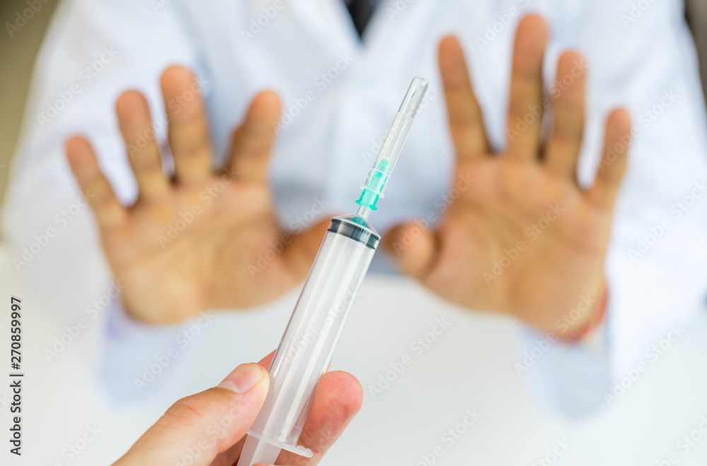 Man gesturing with hand and refusing injection or vaccination Man gesturing with hand and refusing injection or vaccination