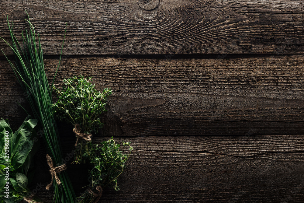 top view of green onion, thyme and basil on wooden weathered table with copy space top view of green onion, thyme and basil on wooden weathered table with copy space