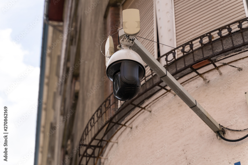 Remote control CCTV security camera attached to an old building facade. Concept of a public security measures Remote control CCTV security camera attached to an old building facade. Concept of a public security measures