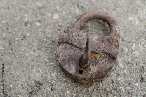 Old rusty metal lock closeup on cement floor