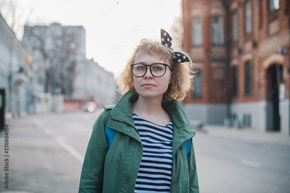 Portrait of a young woman on the background of a European sunny street. Portrait of a young woman on the background of a European sunny street.