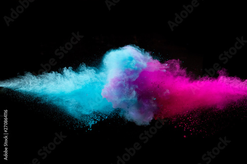 Colored powder collision on black background. Freeze motion. photo