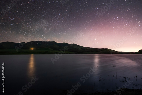 The space of the universe. Beautiful panoramic view of the the lake and mountain with Milky Way galaxy.