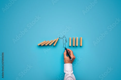 Handdrawn businessman stopping falling dominos photo