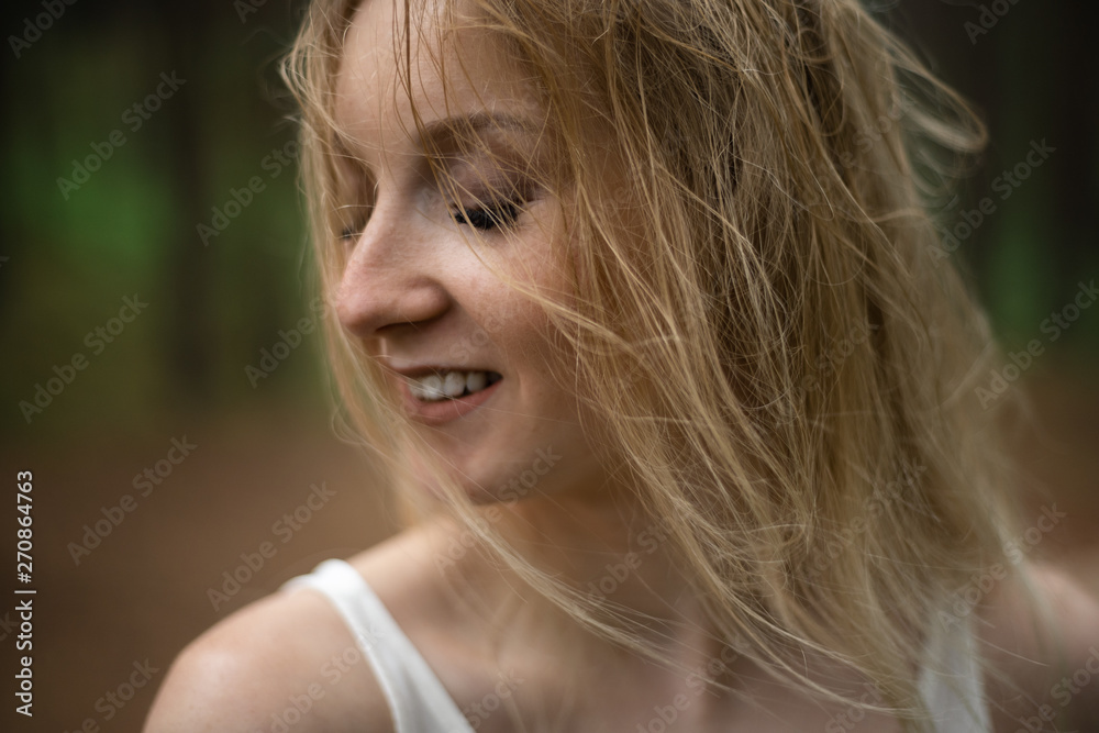 Close up portrait - Beautiful young blonde woman forest nymph in white dress in evergreen wood Close up portrait - Beautiful young blonde woman forest nymph in white dress in evergreen wood