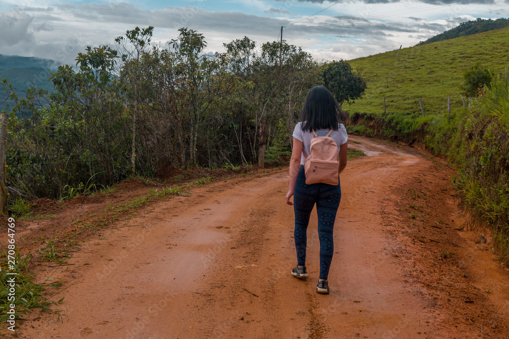 young woman walking alone in rural way