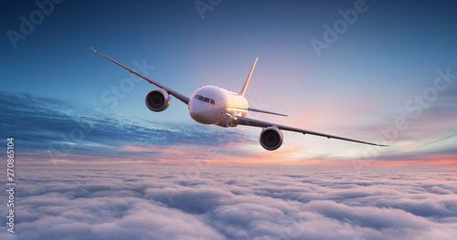 Commercial airplane jetliner flying above dramatic clouds in beautiful sunset light. Travel concept. photo
