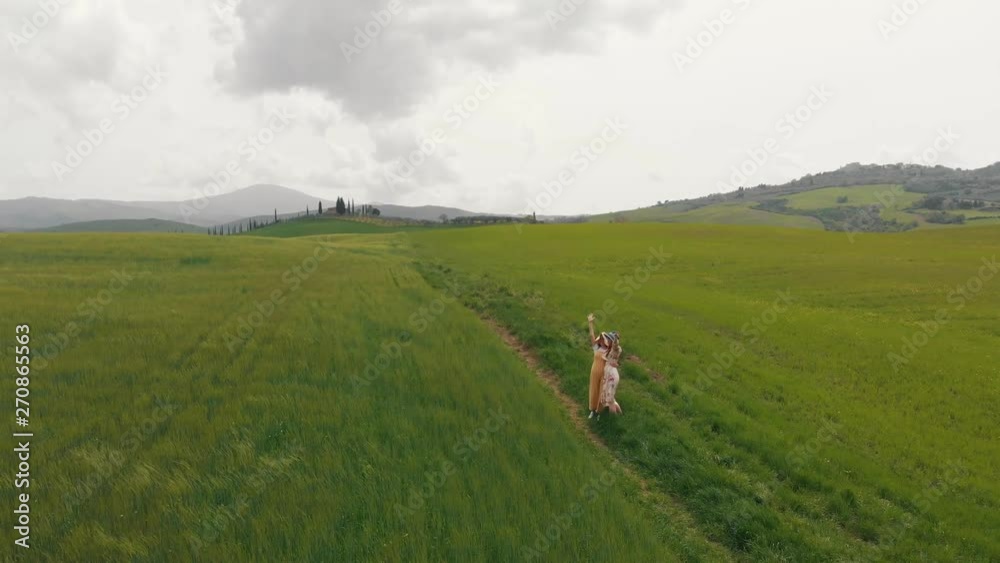 Two young women embracing. waving their hands. Italy, Toskana.