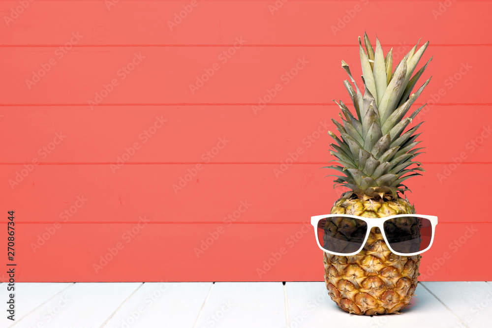 Hipster pineapple with sunglasses against a living coral colored wood background. Minimal summer concept. - obrazy, fototapety, plakaty 